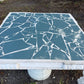 Close-up of the slate blue broken-tile mosaic top and molded edge of a concrete table