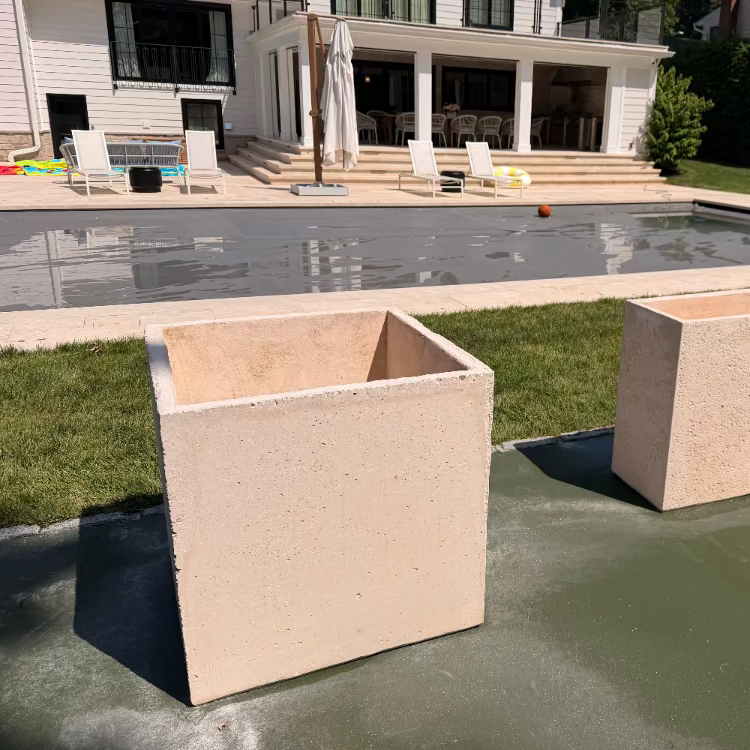 Large concrete square planters used to perimeter this home's basketball court and  pool