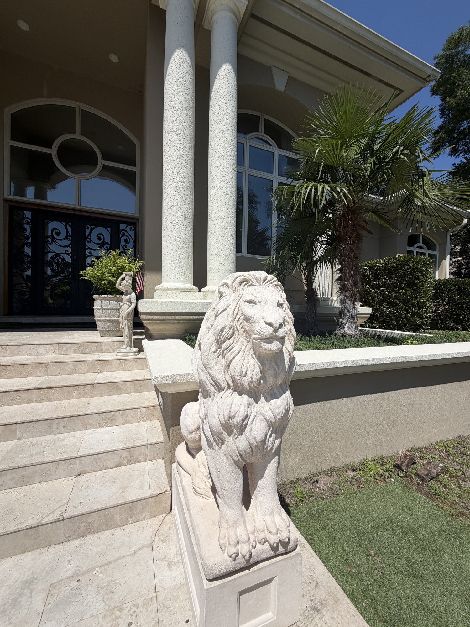 Close-up detail of a hand-finished concrete lion statue at an estate entrance