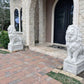 Large Florida Home receives concrete lion statue on square pedestal at entrance of stone estate
