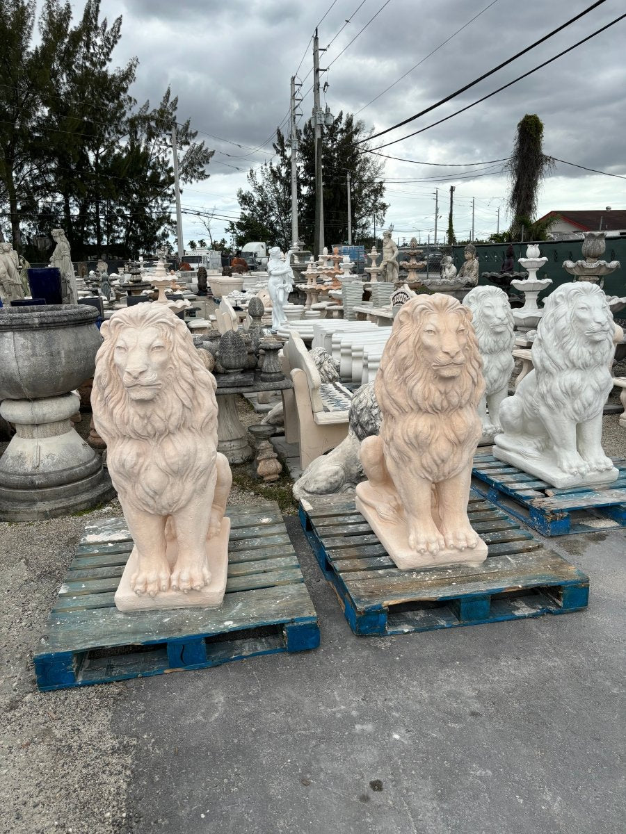 Group of beige concrete lion statues lined up for shipping to Texas
