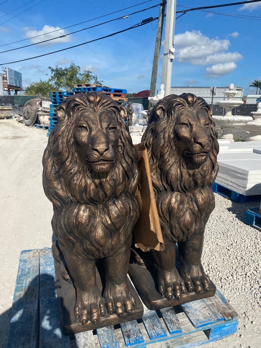 Pair of large bronze concrete lion statues on pallet ready for shipment