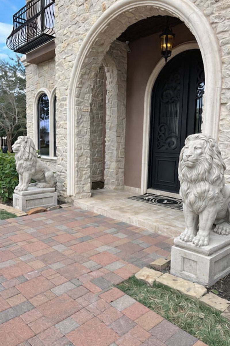 Pair of Gray concrete lion statues on square pedestal at entrance of estate shipped to Houston, Texas