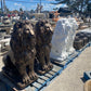Row of handcrafted concrete lion statues lined up on wooden pallets for shipping to California