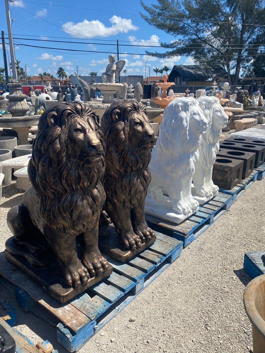 Row of handcrafted concrete lion statues lined up on wooden pallets for shipping to California