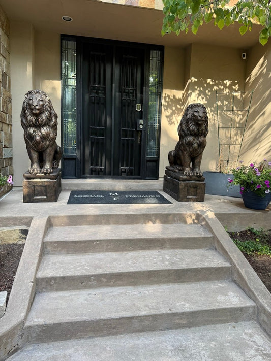 Large concrete lion statues flanking outdoor steps leading to a porch entrance